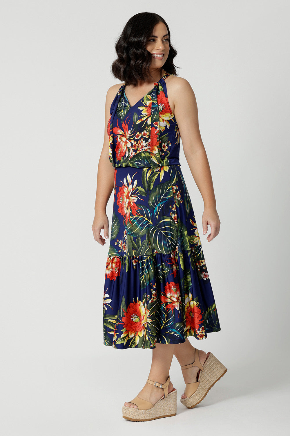 A midi floral dress for cruise holidays and resort style perfect for summer Easy care slinky jersey dress worn by petite woman shows length of dress.  This floral jersey fabric is easy-care and crease-resistant. Australian made for Australian and New Zealand women. Fashion brand Leina & Fleur stock sizes in sizes 8 to 24. Shop easy travel pieces online.