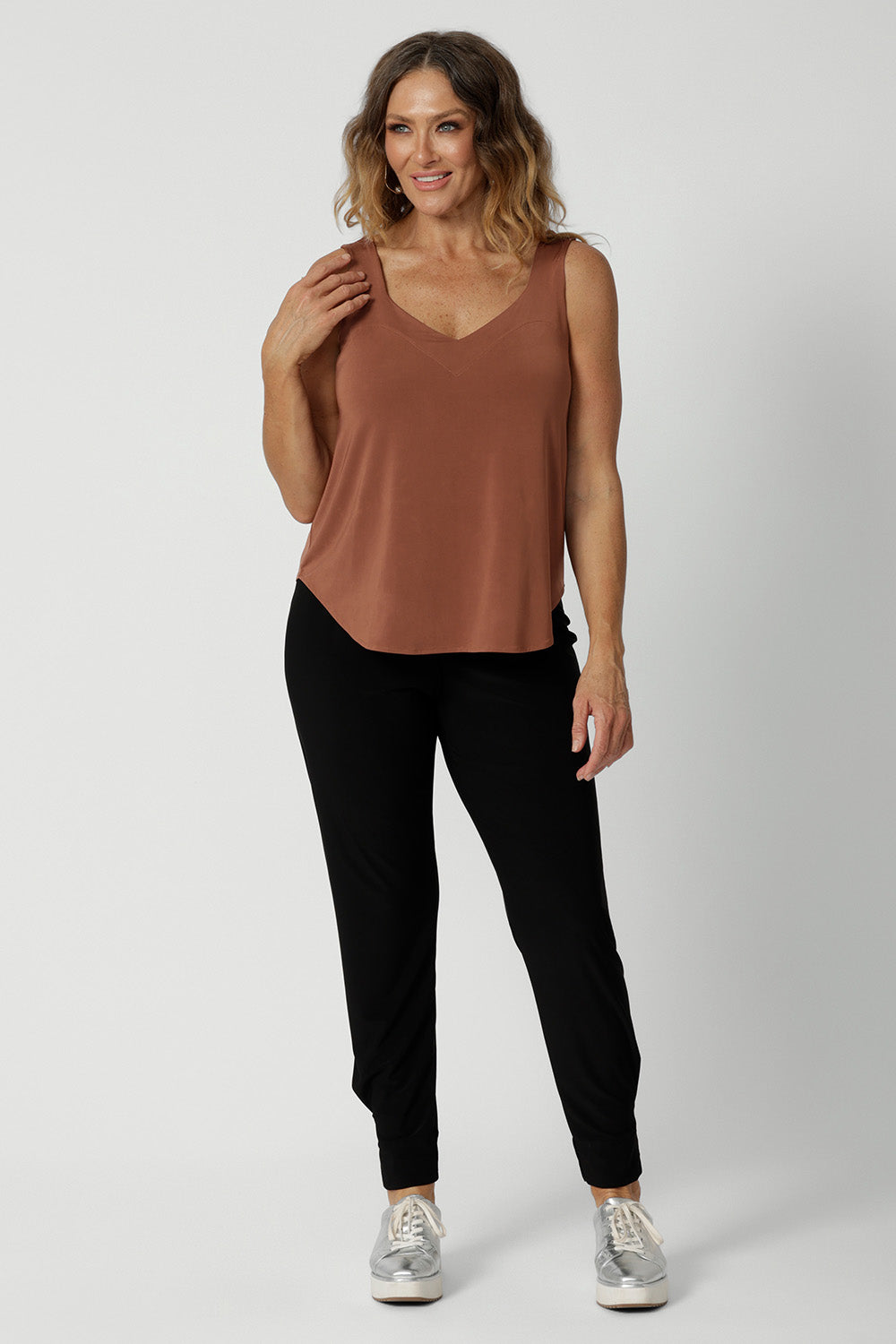 A great plus size cami top for off duty wear or event dressing. Shown on as a top for over 40s women on a size 12 woman, this cami top is worn with tapered leg travel pant in black. Eddy Cami in Clay has wide shoulder straps, a soft V-neckline and loose fitting slinky jersey body. Made in Australia by Australian fashion brand, Leina & Fleur.