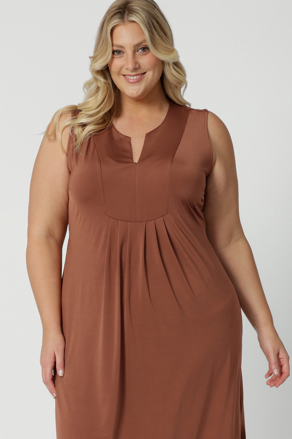 Close up of the bodice of a plus size sleeveless dress in clay coloured slinky jersey fabric. A dress for curvy women., it's made in Australia by Australian and New Zealand women's clothing brand, Leina & Fleur, this flattering empire line midi dress is made for plus size women, available in sizes 16 to 24. Perfect for showing off curves with a comfortable fit.