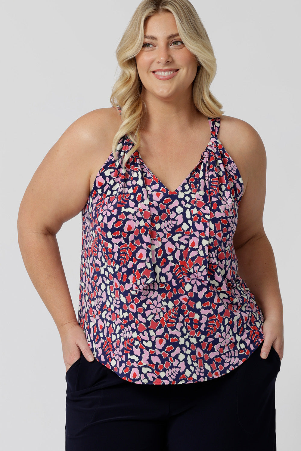 A good summer top for plus size women, this halter neck top is a comfortable, easy-care top.  Shown ona. size 18  woman as a plus size and curve top, in red, pink, white and navy print, this slinky jersey top is a made in Australia top by Australian and New Zealand women's clothes brand, Leina & Fleur, shop their petite to plus size tops online. 