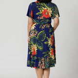 Back view image of petite model wearing floral wrap dress. Easy care summer dress is made of slinky jersey that is crease-resistant perfect for packing in a suitcase. Comfortable fit dress is flattering and relaxed for all occasions. Leina & Fleur stock this wrap dress in sizes 8-24. 