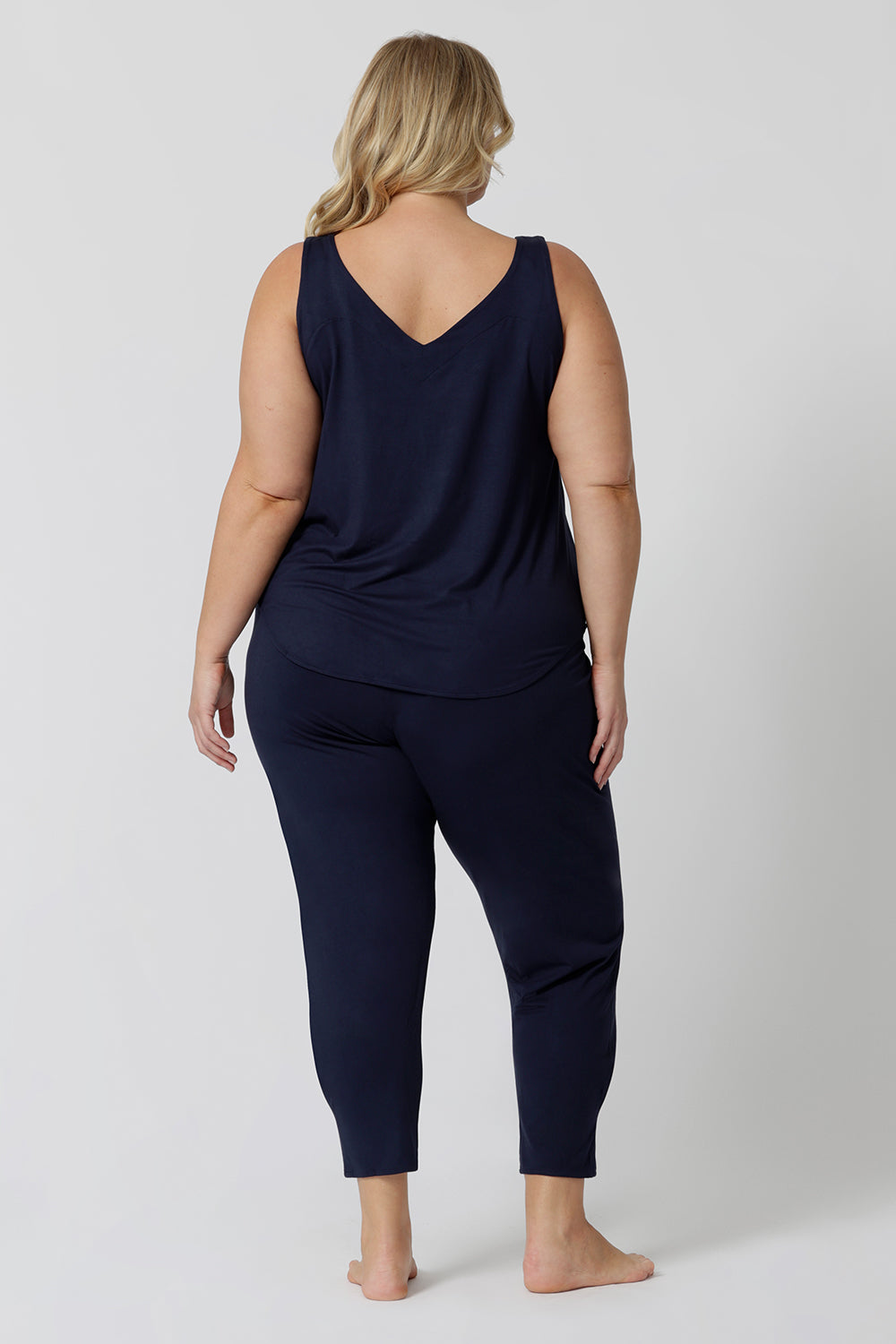 Back view of a good loungewear pant for curvy women. This navy bamboo tapered leg,  plus size pant is a pull-on pyjama pant. Worn with navy bamboo cami top, this is a breathable, thermo-regulating pyjama set and makes get sleepwear for night sweats and hot flushes. Shop loungewear sets online at L&F Australia.