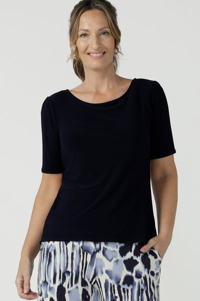 A beautiful and comfortable workwear top for plus size, curvy women, this short sleeve, boat neck top in navy blue is shown on a size 8. A quality top for workwear, this slim fit jersey top is made in Australia by women's clothing brand, Leina & Fleur.