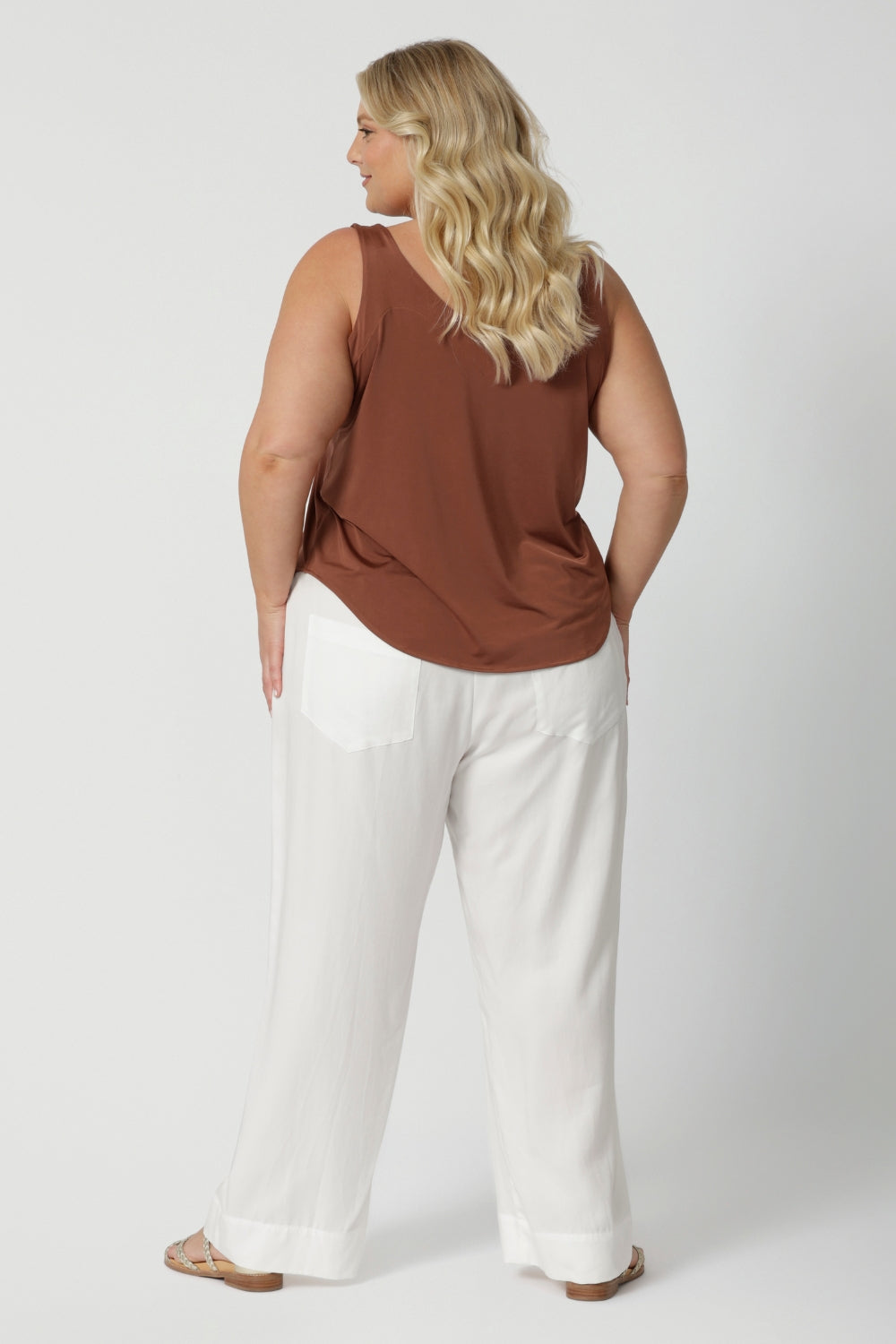 Back view of curvy size 18 L&F model wears white casual pant. Pull-on style pant is made of easy care lyocell fabric that is comfortable for your everyday wardrobe. Shop these wide leg pants in sizes 8 to 24. Leina & Fleur actively stocks petite and plus sizes on their website. 