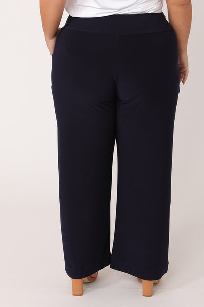 Back view of straight, wide-leg navy pants cut in petite length. These petite length work pants are comfortable in pull-on jersey fabric and are Australian-made in sizes 8 to 24.