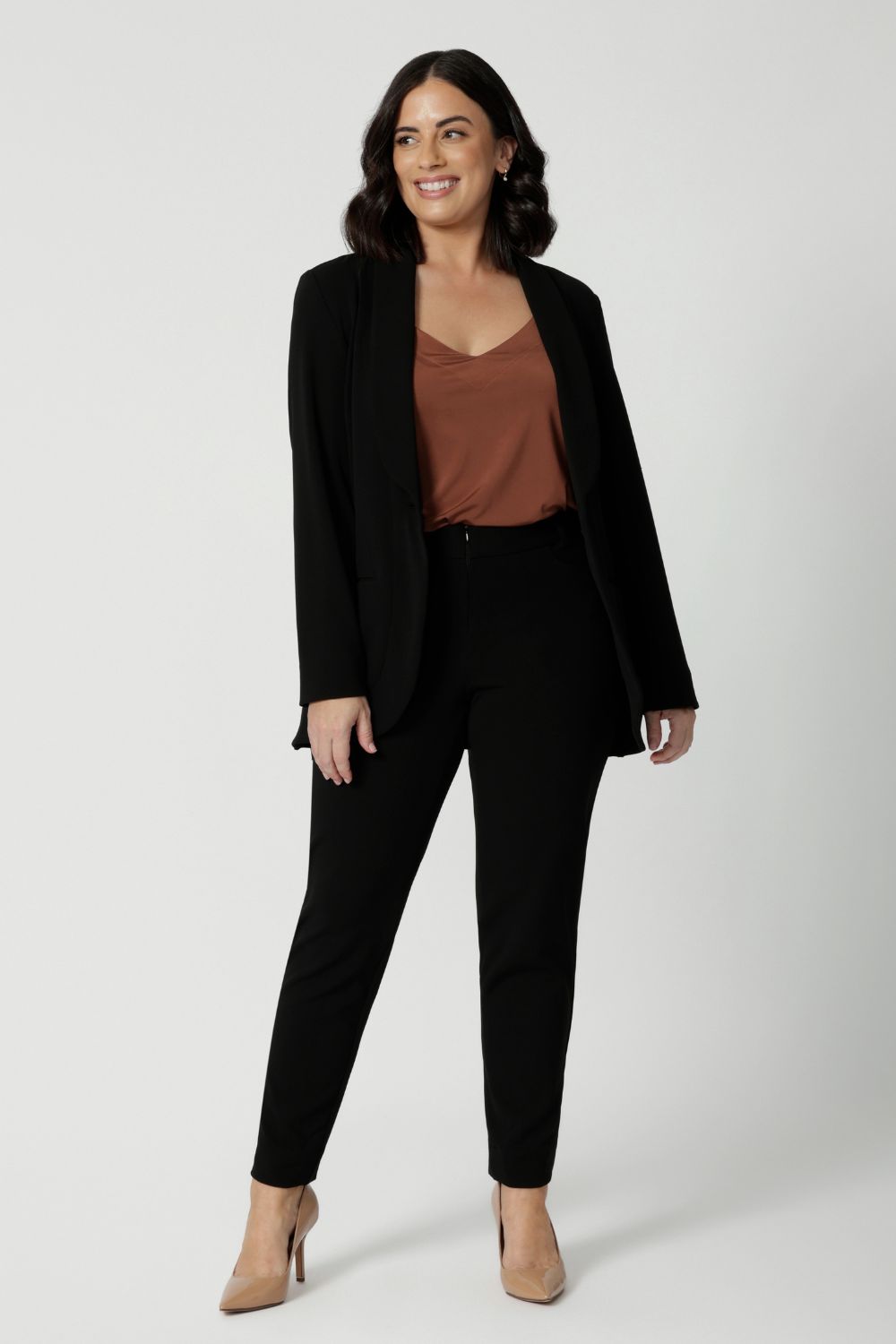 Leina & Fleur's petite sized model wearing black workwear blazer. Designed for modern professionals who value functionality and comfort. Woman's fashion brand Leina & Fleur stock soft suiting in sizes 8 to 24. Find this easy care work blazer and matching suit pants in plus size and petite sizes.