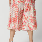 Back view orange-red polka dot print, plus size culottes in luxurious Italian viscose fabric. Made in Australia by women's clothing brand, Leina & Fleur, these curve culottes are worn with a plus size cami top in mineral blue. Shop this summer wedding guest and event wear outfit online in sizes 8 to 24.