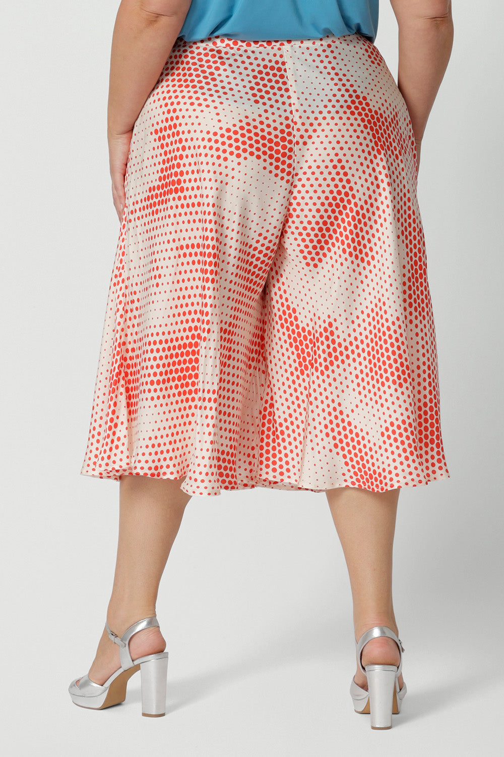 Back view orange-red polka dot print, plus size culottes in luxurious Italian viscose fabric. Made in Australia by women's clothing brand, Leina & Fleur, these curve culottes are worn with a plus size cami top in mineral blue. Shop this summer wedding guest and event wear outfit online in sizes 8 to 24.