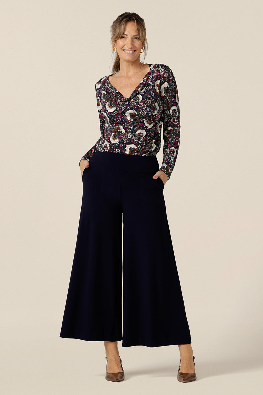 A size 10 woman wears wide leg pull-on pants in navy stretch jersey. Comfortable pants for work and casual wear, these cropped trousers are made in Australia by women's clothing brand, Leina & Fleur. 