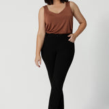 A great petite height-friendly cami top for off duty wear or event dressing. Shown on as a top for petite women, this cami top is worn with tapered leg black pants women will love. Eddy Cami in Clay has wide shoulder straps, a soft V-neckline and loose fitting slinky jersey body. Made in Australia by Australian fashion brand, Leina & Fleur.