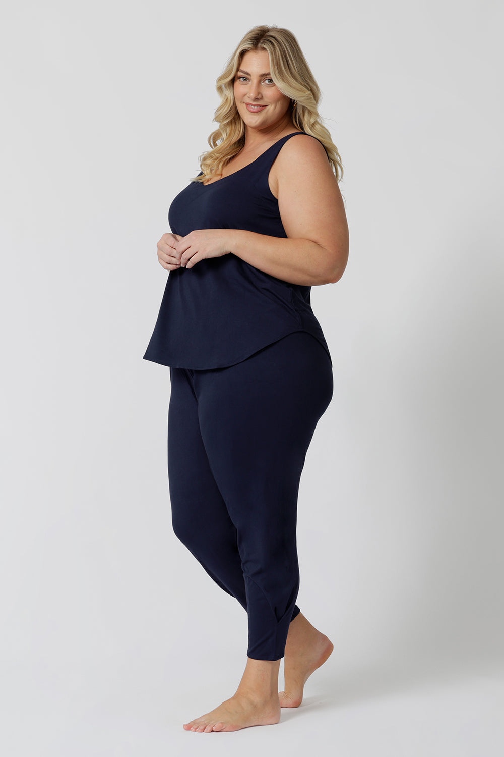 Side view of a  good loungewear pant for curvy women. These navy bamboo tapered leg,  plus size pants are pull-on pyjama pants. Worn with navy bamboo cami top, this is a breathable, thermo-regulating pyjama set and makes get sleepwear for night sweats and hot flushes. Shop loungewear sets online at L&F Australia.