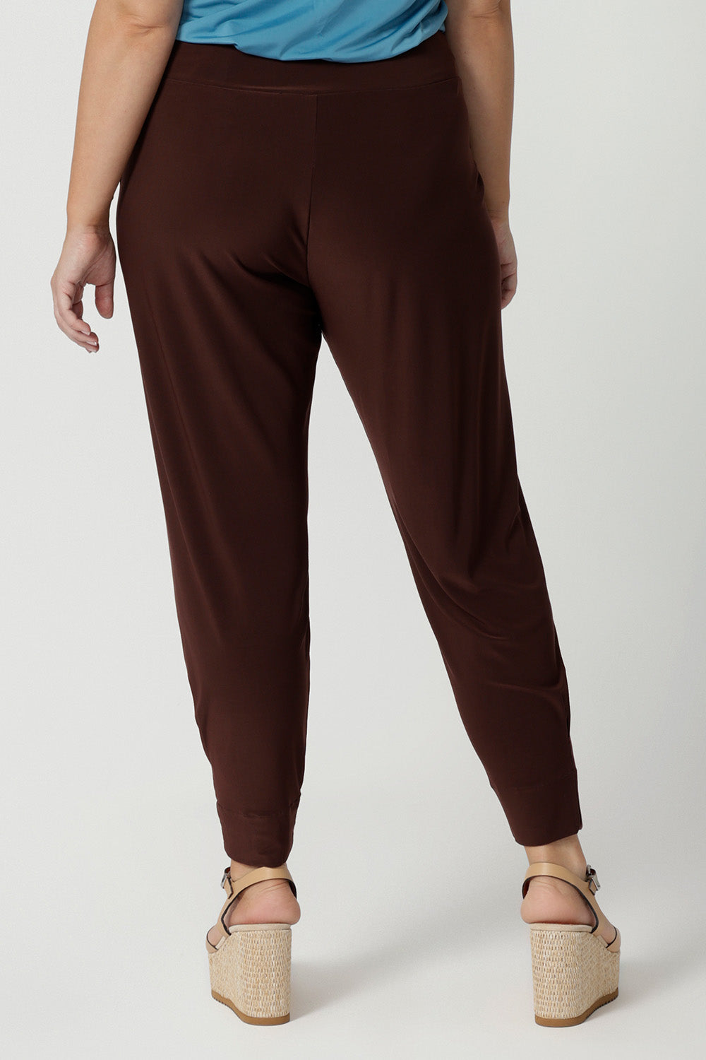 Back view of good off duty trousers for petite women. These tapered leg pants by Australian and New Zealand women's clothes brand, Leina & Fleur are comfortable stretchy pants in espresso brown jersey fabric. Shop pants for petite height women online in sizes 8 to 24.