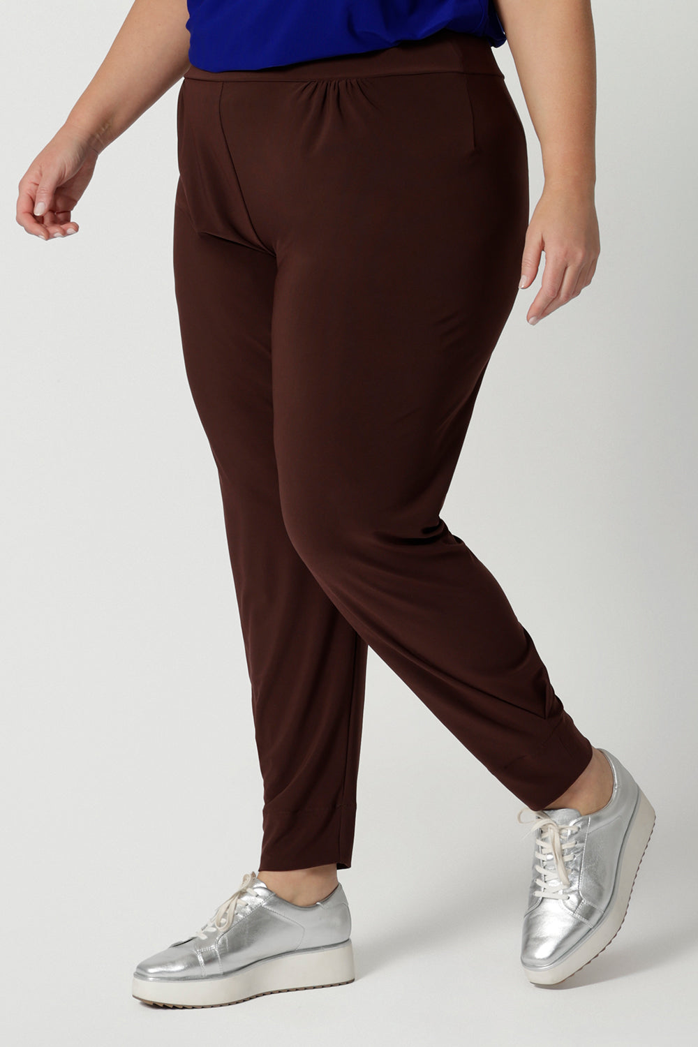 Close up of off duty pants for tall, plus size women, these tapered leg, long length pants by Australian and New Zealand women's  clothing brand, Leina & Fleur are comfortable stretchy pants in espresso brown jersey fabric. Shop travel pants for plus size women and ladies tall pants online in sizes 8 to 24.