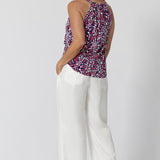 BAck view of  a summer top for over 40s women. This halter neck top is a comfortable, easy-care top worn with white pants for summer.  In red, pink, white and navy print, this slink jersey top is a made in Australia top by Australian and New Zealand women's clothes brand, Leina & Fleur, shop their petite to plus size tops online. 