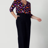 Size 12 woman wears the Jaime top in Palette. A brush stroke inspired abstract print on a navy base with fuchsia, red, orange and pink spots. A v-neck pleat front top great for work to weekend. Comfortable jersey and easy care. Made in Australia for women size 8 - 24. Styled back with navy tailored pants.