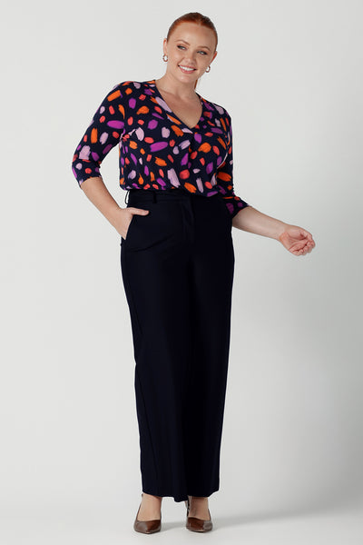 Size 12 woman wears the Jaime top in Palette. A brush stroke inspired abstract print on a navy base with fuchsia, red, orange and pink spots. A v-neck pleat front top great for work to weekend. Comfortable jersey and easy care. Made in Australia for women size 8 - 24. Styled back with navy tailored pants.