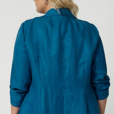 Image showcases teal blazer from the back featuring Australian made tailoring. While the relaxed fit offers versatility for any occasion it is perfect for travel. Provides a light weight style for your journeys. Shop this linen blazer in sizes 8-24.