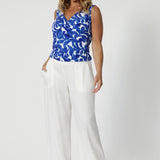 Cowl neck top showcases bust lining that provides extra support, structure and coverage ensuring comfort throughout the day. Versatile and summer-ready, this top can easily be dressed up for a more refined look or dressed down for a casual, effortless style. Model wears printed top with white pants and a heel for an elevated  look. Available in sizes 8-24.