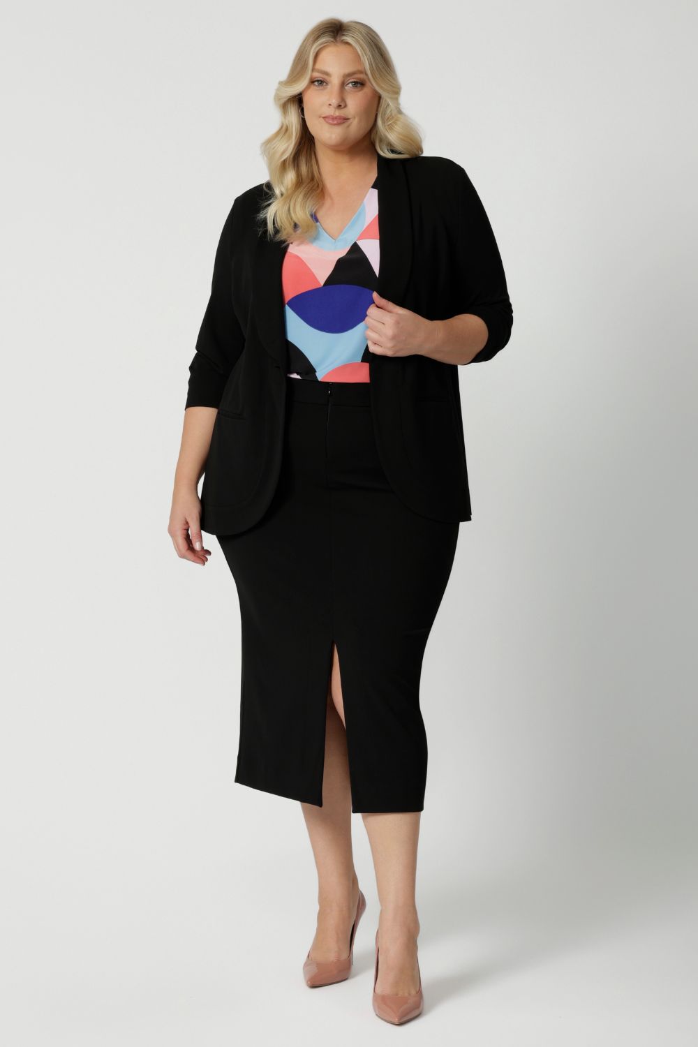 Leina & Fleur's plus sized model wearing black workwear blazer. Manufactured for modern professionals who values style, functionality and comfort. Womans clothing brand Leina & Fleur stock soft suiting in sizes 8 to 24. Find this easy care work blazer and matching suit pants in plus size and petite sizes.