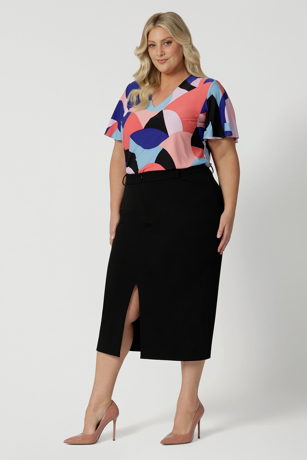 Leina & Fleur's plus size straight-cut black midi skirt, is crafted in lightweight scuba crepe jersey for curvy women. With a front split, this skirt with pockets is worn with a flutter sleeve women's top in coral and cobalt print. Made in Australia by the Australian and New Zealand women's clothing brand, this easy-care, stretchy skirt delivers comfort and style for plus size women - available in skirt sizes 8 to 24.