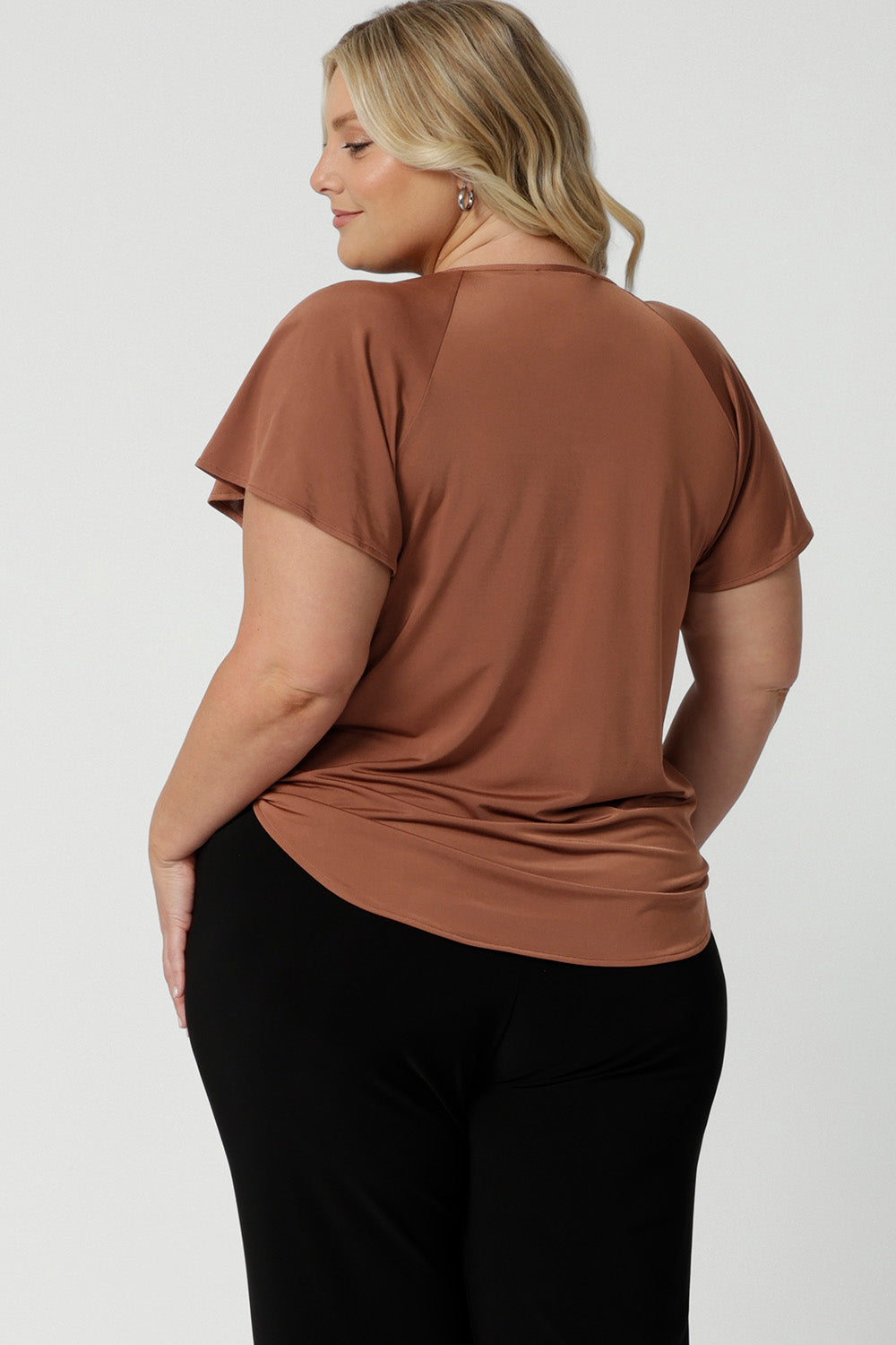 Back view of a summer top for plus size women. A size 18 woman wears a flutter sleeve top in clay slinky jersey fabric. An easy-care top for travel and cruise wear, this made-in-Australia V neck top is by Australian and New Zealand women's clothes label, Leina and Fleur shop petite to plus size tops for women  online.