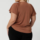 Back view of a summer top for plus size women. A size 18 woman wears a flutter sleeve top in clay slinky jersey fabric. An easy-care top for travel and cruise wear, this made-in-Australia V neck top is by Australian and New Zealand women's clothes label, Leina and Fleur shop petite to plus size tops for women  online.