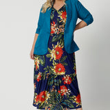 Plus sized woman wears floral maxi dress paired with blazer. This maxi dress is a travel ready piece. Designed in Australia with easy care fabric made of slinky jersey. Leina & Fleur brand stock sizes from 8-24. Shop this summer ready dress in petite sizes and plus sizes.
 