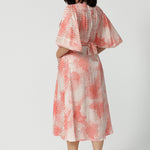 Back view of a good dress for petite women, this silky wrap dress has an orange spot print and 3/4 lantern-shaped sleeves. Made in Australia by women's clothing brand, Leina & Fleur, wear this 3/4 sleeve wrap dress for wedding guest outfit and summer event  wear. Shop this summer wedding guest and event wear outfit online in sizes 8 to 24.