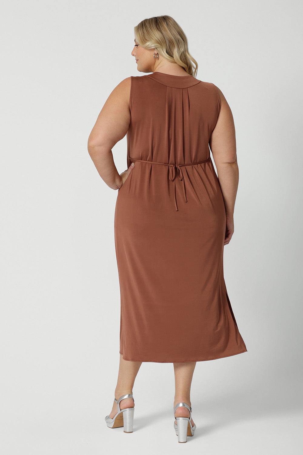 Back view of a good plus size sleeveless dress in clay coloured slinky jersey fabric. A dress for curvy women, it's made in Australia by Australian and New Zealand women's clothing brand, Leina & Fleur, this flattering empire line midi dress is made for plus size women, available in sizes 16 to 24. Perfect for showing off curves with a comfortable fit.