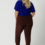 Back view of off duty pants for tall, plus size women, these tapered leg, long length pants by Australian and New Zealand ladies clothing brand, Leina & Fleur are comfortable stretchy pants in espresso brown jersey fabric. Shop travel pants for plus size women and ladies tall pants online in sizes 8 to 24.