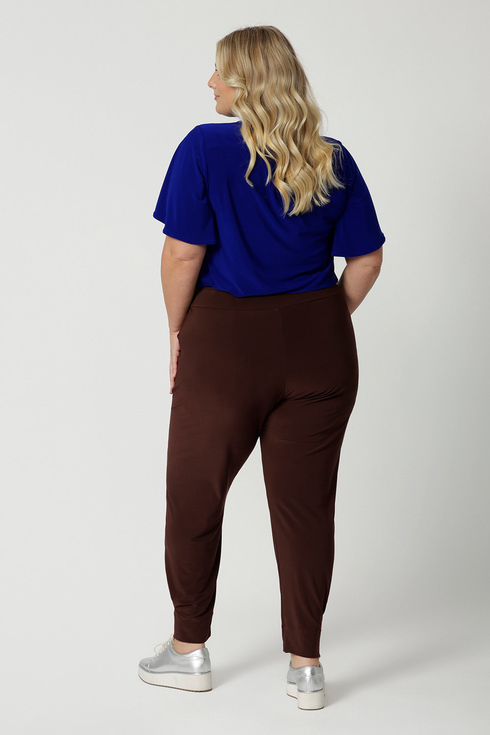 Back view of off duty pants for tall, plus size women, these tapered leg, long length pants by Australian and New Zealand ladies clothing brand, Leina & Fleur are comfortable stretchy pants in espresso brown jersey fabric. Shop travel pants for plus size women and ladies tall pants online in sizes 8 to 24.