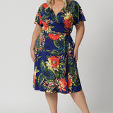 Wrap dress worn by plus sized model has a floral design. The Maggie Knee Length Dress in Bahagia is perfect for cruise holidays and resort style. This floral jersey fabric is easy-care and crease-resistant. Australian made for Australian and New Zealand women. Fashion brand Leina & Fleur stock sizes in sizes 8 to 24. Shop wrap dresses online.