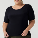 A good top for plus size, curvy women, this short sleeve, boat neck top in navy blue is shown on a size 18. A quality top for workwear, this slim fit jersey top is made in Australia by women's clothing brand, Leina & Fleur.