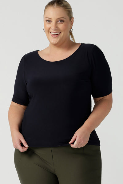 A good top for plus size, curvy women, this short sleeve, boat neck top in navy blue is shown on a size 18. A quality top for workwear, this slim fit jersey top is made in Australia by women's clothing brand, Leina & Fleur.