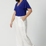 Full body image of petite woman wearing casual wide leg pants. Lightweight lyocell fabric pant is perfect for staying cool in the Australian heat. Designed with a wide leg, these light weight pants offer a relaxed and breezy feel. Versatile pants can be worn for casual outings or beach days. Australian made with quality craftsmanship that celebrates local production and sustainability. Woman's fashion label Leina & Fleur stock sizes 8-24.