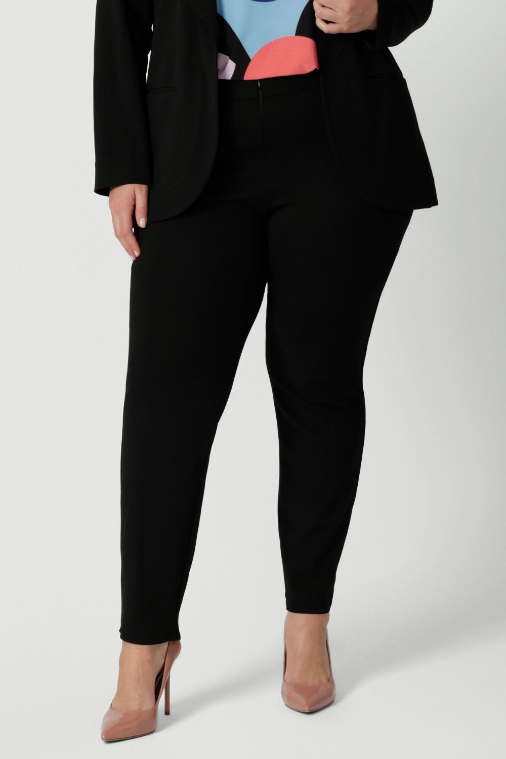 Close up image of pants worn by plus sized model. Easy care pants are made from scuba crepe fabric that provide comfortability and stretch when worn. Image shows pants styled with blazer for a full suiting look. Woman's clothing brand Leina & Fleur is Australian made and have a size offering of 8-24.