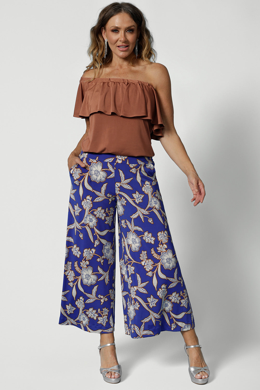 Wide leg pants for summer don't come much better than this! Worn by a size 12 woman, these wide leg pants are in easy care jersey with a blue, caramel and white floral print. Worn with a clay coloured one-shoulder top, these wide leg culottes are made in Australia by Australian and New Zealand women's clothing brand, Leina and Fleur. Shop wide leg pants in petite to plus sizes.