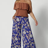 Wide leg pants for summer don't come much better than this! Worn by a size 12 woman, these wide leg pants are in easy care jersey with a blue, caramel and white floral print. Worn with a clay coloured one-shoulder top, these wide leg culottes are made in Australia by Australian and New Zealand women's clothing brand, Leina and Fleur. Shop wide leg pants in petite to plus sizes.