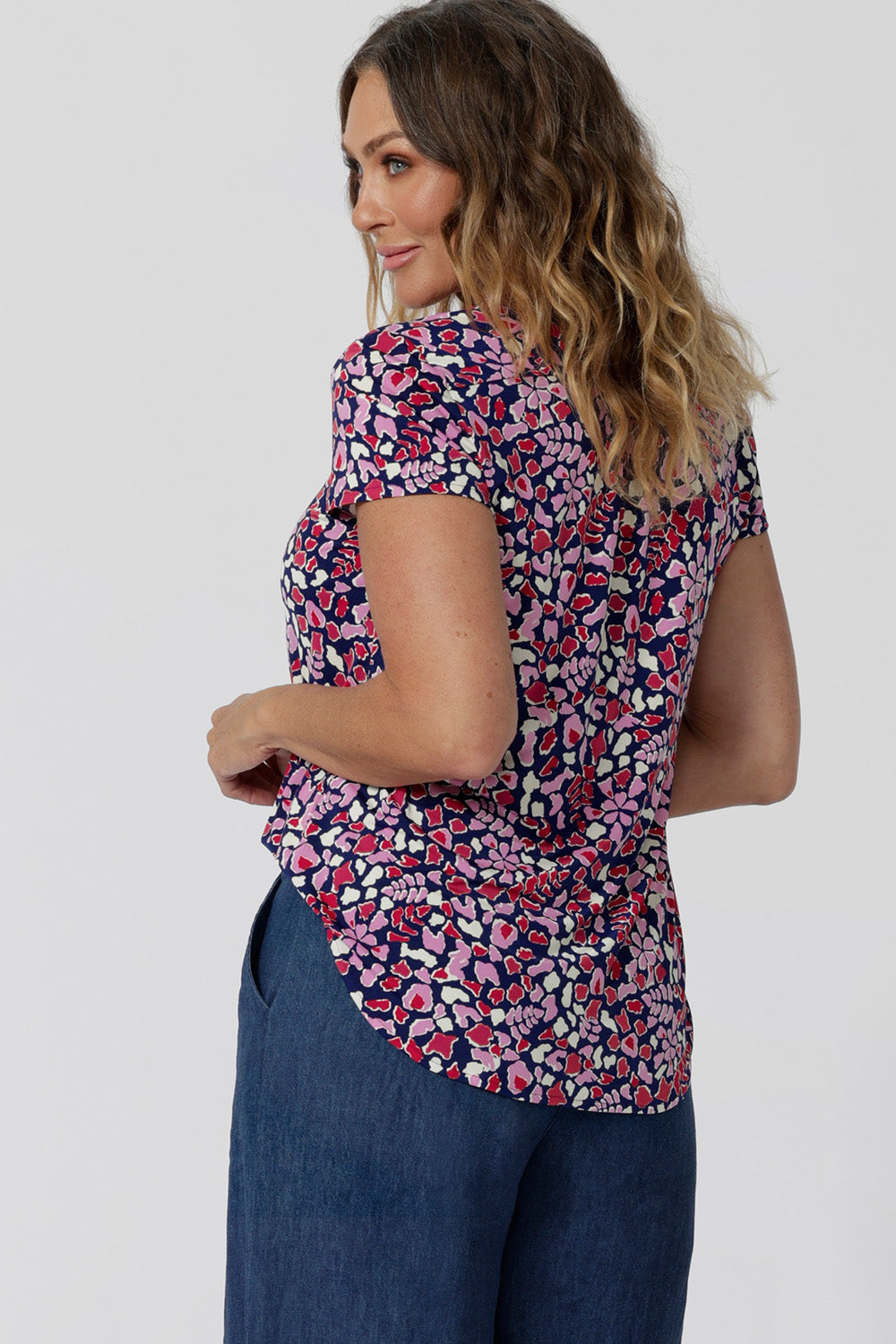 Back view of an off-duty top  for women. This V-neck top with tailored tuck is a comfortable top for women.  A woman with over 40s style   wears short sleeve V-neck jersey top. New Zealand women's clothes brand, Leina & Fleur, shop their petite to plus size tops online. 