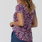 Back view of an off-duty top  for women. This V-neck top with tailored tuck is a comfortable top for women.  A woman with over 40s style   wears short sleeve V-neck jersey top. New Zealand women's clothes brand, Leina & Fleur, shop their petite to plus size tops online. 