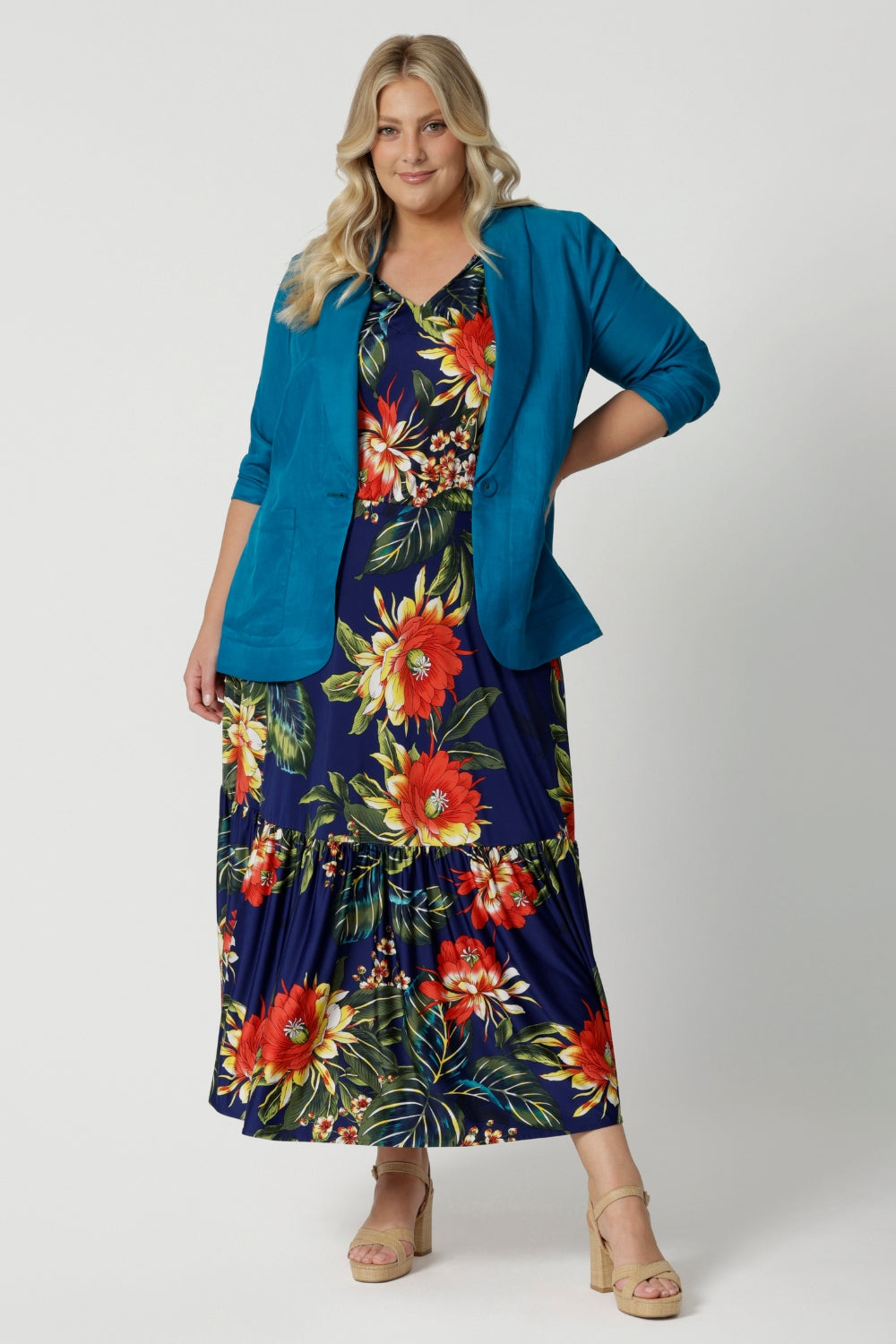 Leina & Fleur's plus sized model wears teal blazer over summer ready floral dress. Linen blazer is in the colour teal. Linen, tencel and cupro were the breathable fabric used to create this breathable blazer. Leina & Fleur stocks sizes from 8-24. Shop this resort ready blazer in petite sizes and plus sizes. 