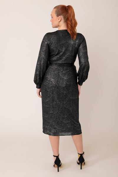 Back view of a woman wearing a good cocktail dress for curvy women. A long sleeve wrap dress, this event dress shimmer in metallic foil print. A statement going out dress, the Carys dress is made in Australia by occasionwear brand Leina & Fleur.