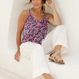 As a summer top for over 40s women, this halter neck top with is a comfortable, easy-care top is worn with white sumemr pants..  In red, pink, white and navy print, this slink jersey top is a made in Australia top by Australian and New Zealand women's clothes brand, Leina & Fleur, shop their petite to plus size tops online. 