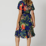 This easy care wrap dress is crease resistant making it perfect for travel. Printed dress has orange, yellow and white flowers on a deep blue base. Designed in Australia with easy care fabric for Australian and New Zealand woman. Sizes 8-24. Proudly made in Australia, supporting local artisans. 