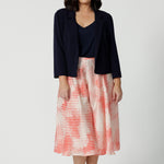 A good petite wedding guest outfit, a petite,  size 10 woman wears orange-red polka dot print culottes in luxurious Italian viscose fabric with navy cami top and navy jacket. Made in Australia by women's clothing brand, Leina & Fleur, these lightweight culottes are are perfect off-duty summer shorts and pants alternatives. Shop this summer wedding guest and event wear outfit online in sizes 8 to 24.