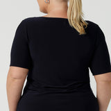 back view of a good top for plus size, curvy women. This short sleeve, boat neck top in navy blue is shown on a size 18. A quality top for workwear, this slim fit jersey top is made in Australia by women's clothing brand, Leina & Fleur.