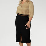 This stretchy, easy-care skirt is a perfect workwear piece for elevated suit styling with matching jacket or blazer. Size 18 model wears her midi length workwear skirt with brown kitten heels and a gold collared blouse.