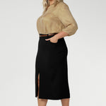 This stretchy, easy-care skirt is a perfect workwear piece for elevated suit styling with matching jacket or blazer. Size 18 model wears her midi length workwear skirt with brown kitten heels and a gold collared blouse. Available in sizes 8-24.