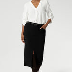 Australian made black workwear skirt seen on over 40's woman paired with opal coloured shirt and black heels for an elevated workwear look. Sizes 8-24 available at Leina & Fleur.