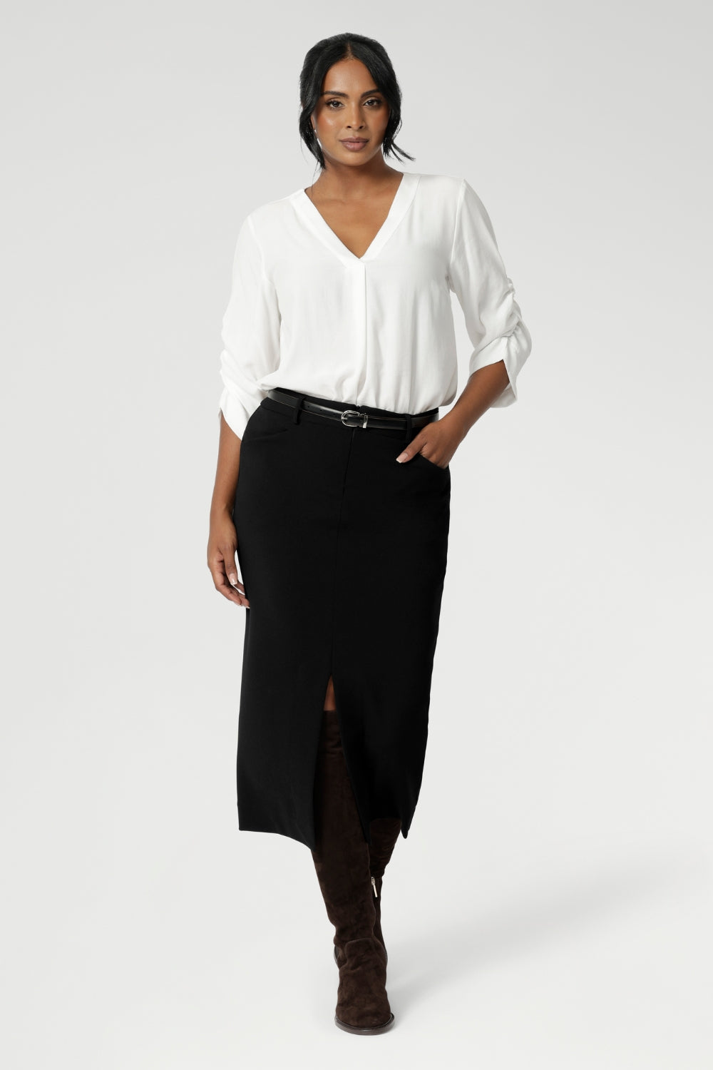 Australian made black workwear skirt seen on over 40's woman paired with opal coloured shirt and black heels for an elevated workwear look. Sizes 8-24 available at Leina & Fleur.